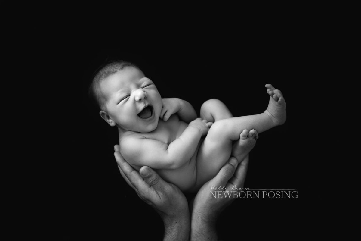 in parent's hands or simba pose for newborn photography by kelly brown
