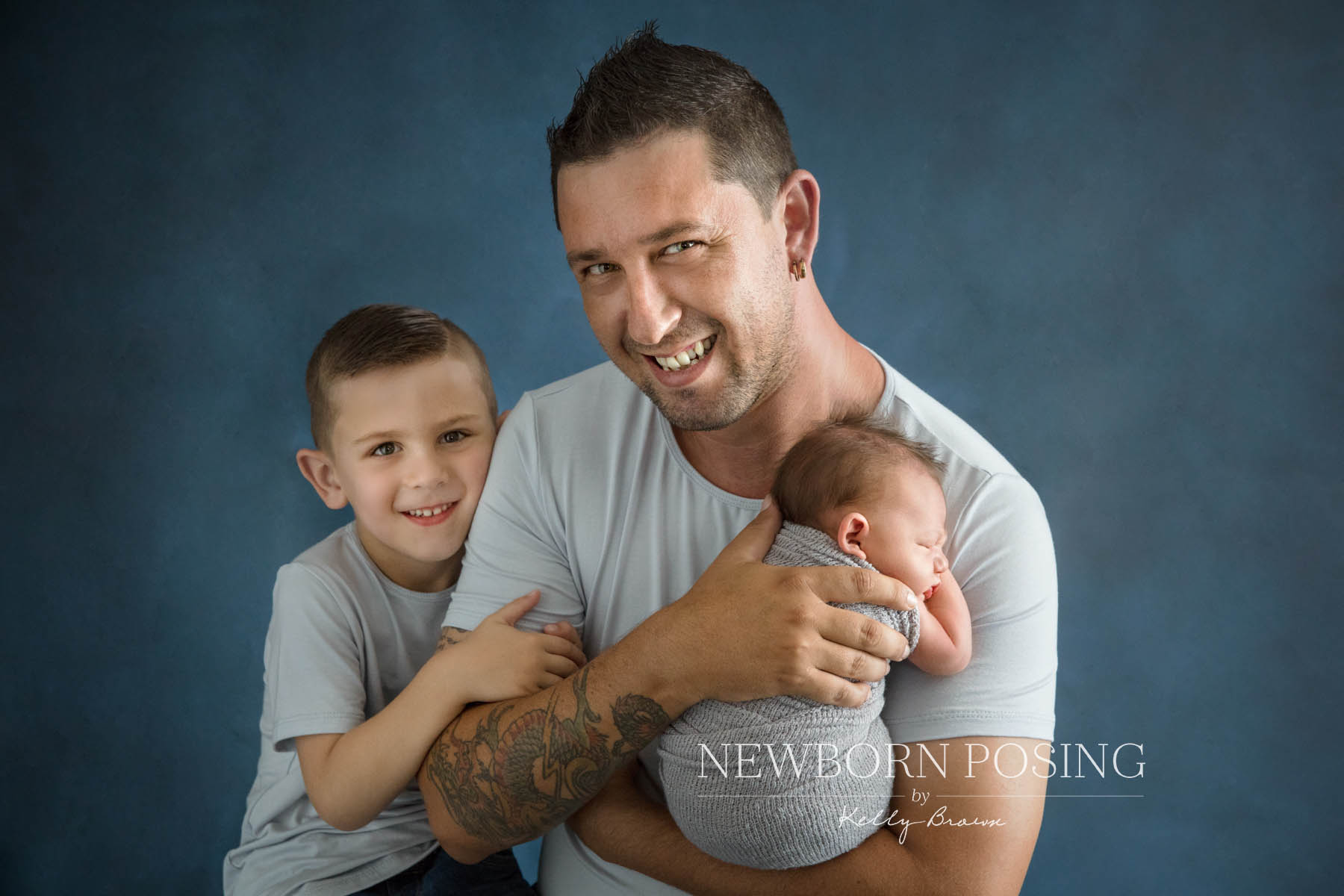 Newborn photography of father and son cuddling baby