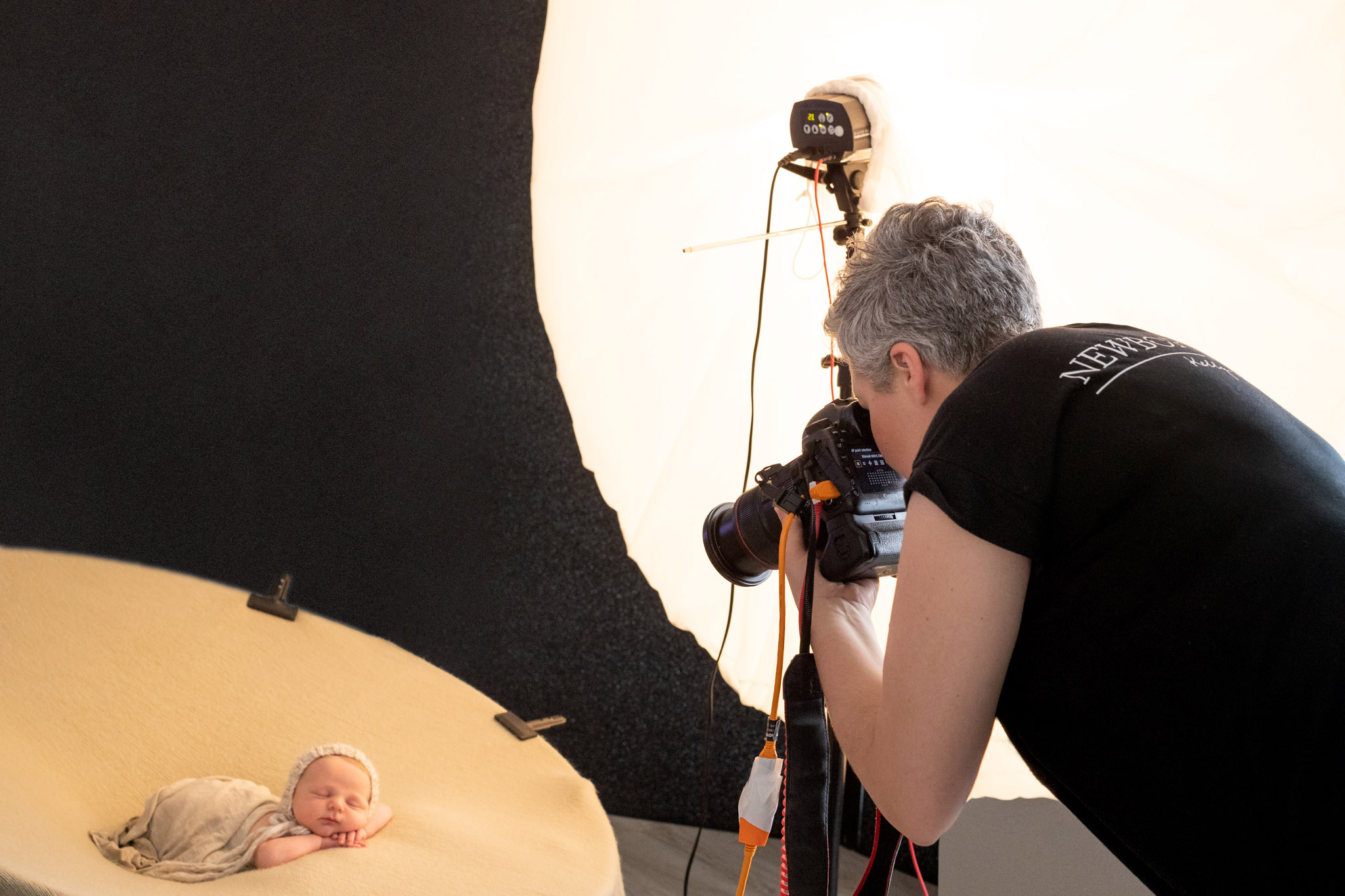 kelly brown with elinchrom dlite rx one studio flash photographing newborn on posing bag